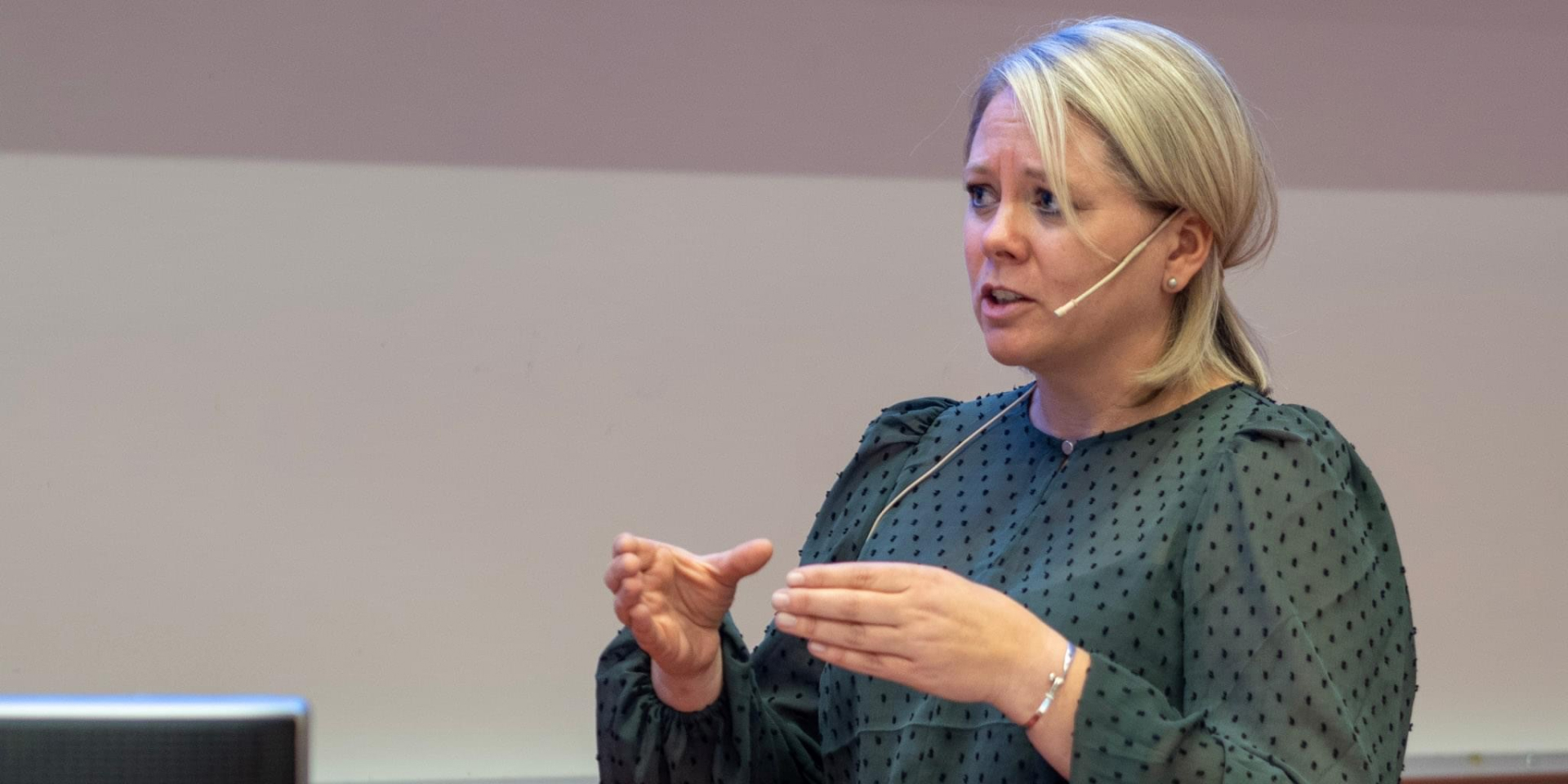 Bilde av Margit Gausdal som snakker om foskningen sin for en forsamling.